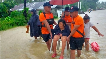 Rettungskräfte evakuieren Bewohner aus einem überschwemmten Gebiet auf den Philippinen.