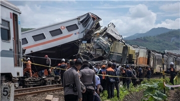 Rettungskräfte inspizieren die Zugwracks nach dem Zusammenstoß in Indonesien.