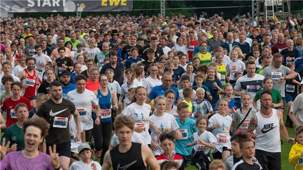 sehr viele Menschen in Sportbekleidung laufen zusammen.