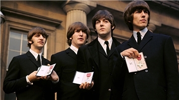 Ringo Starr, John Lennon, Paul McCartney und George Harrison zeigen ihre MBE-Insignien auf dem Vorplatz des Buckingham Palace, nachdem sie von Königin Elisabeth II. empfangen wurden.
