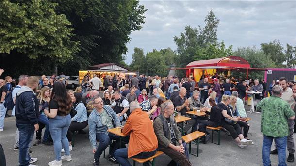 Genial und kostenlos - bei Rock am Fleeth spielen sieben geniale Bands Leute sitzen auf Biergartenbänken