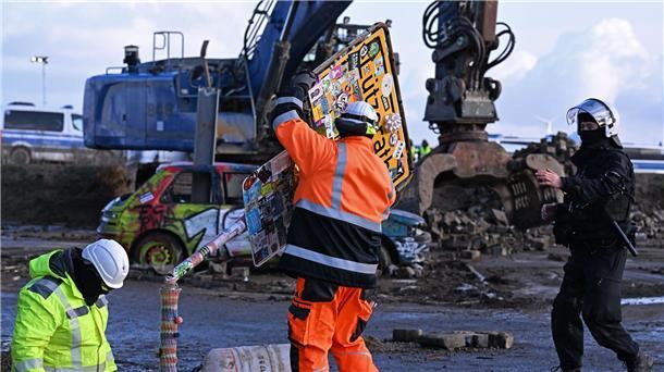 Abrissbagger in Lützerath - Widerstand bröckelt RWE-Mitarbeiter entfernen das Ortsschild des Dorfes Lützerath.