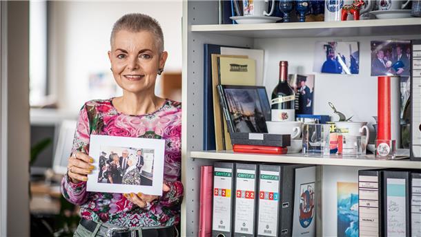 Eine Frau hält ein Foto in den Händen.