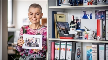 Eine Frau hält ein Foto in den Händen.