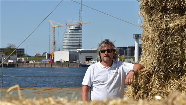 Sachverständiger Dieter Reichelt lässt Strohballen stapeln auf dem Schwerlast-Ponton. Daraus baut er ein „Bett“ für die Mauern des Leuchtturms.