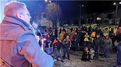 Musiker spielt bei Demo Gitarre und singt dazu