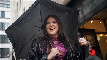 Sängerin Mae Muller steht mit einem Regenschirm vor dem BBC Wogan House. Gastgeberland Großbritannien schickt beim diesjährigen Eurovision Song Contest (ESC) die englische Sängerin Mae Muller ins Rennen.