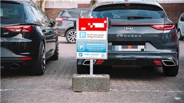 Parkende Autos und ein Hinweisschild auf einen Kundenparkplatz
