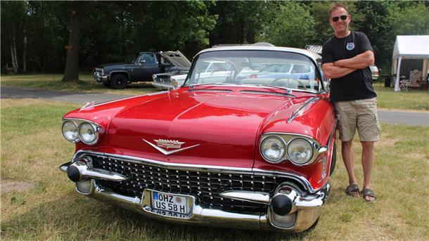 Christoph Meyer lehnt an seinem roten Cadillac Fleet Wood, Baujahr 1958