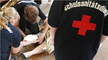 Schüler leisten in einer gestellten Situation Erste Hilfe.