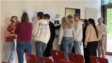 Schüler blicken auf eine Planzeichnung. Veranstaltung zum Campus-Projekt Zeven.
