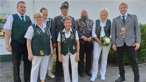 Gruppenfoto mehrerer Mitglieder des Schützenvereins Spaden in traditioneller Vereinskleidung, darunter das neue Königspaar. Einige tragen Schützenketten oder Blumen.