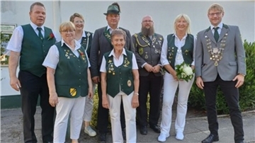 Gruppenfoto mehrerer Mitglieder des Schützenvereins Spaden in traditioneller Vereinskleidung, darunter das neue Königspaar. Einige tragen Schützenketten oder Blumen.