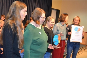 Schulleiterin Heike Gathmann mit der UNICEF-Urkunde und Trainerin Franziska Just sowie die Mitglieder der Steuerungsgruppe, Sandra Houers, Sandra Festin und Sandra Grützmacher (von rechts) mit dem Siegel.