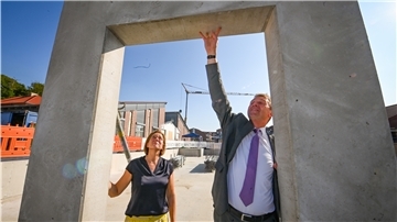 Schulleiterin Isabella Grüninger und Landrat Kai-Uwe Bielefeld „legen Hand an“ am Erweiterungsbau des Langener Gymnasiums.