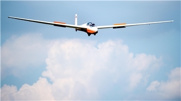 Das Foto zeigt ein Segelflugzeug in der Luft. 