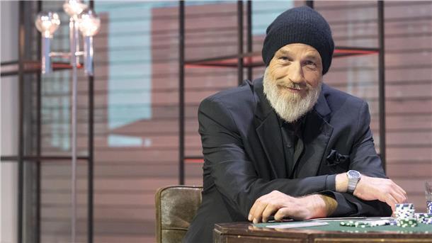 Neue Show: Torsten Sträter Einsichten über Problemzonen im Alltag Torsten Sträter sitzt in einem Fernsehstudio vor einem Tisch.