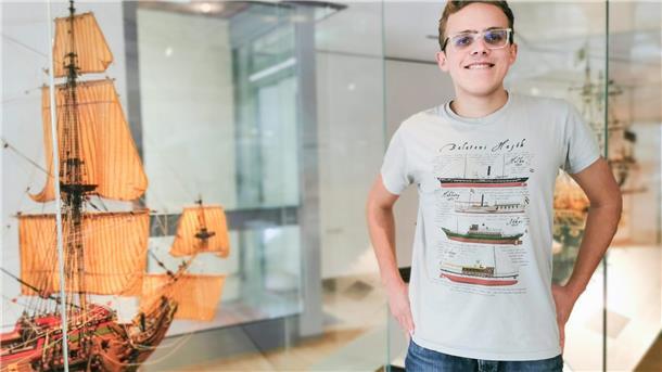 Bojta Buzás Márton trägt ein T-Shirt, auf dem historische Schiffe vom Balaton zu sehen sind.