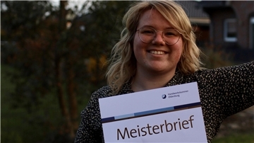 Justine Jäschke zeigt ihren Meisterbrief