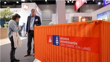 Zwei Menschen an einem Tourismusstand.