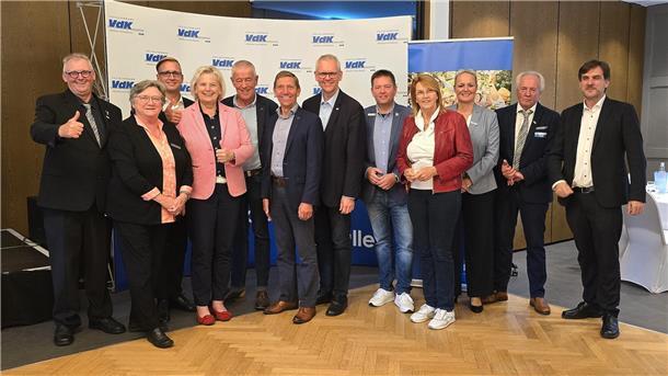 Eine Gruppe von Damen und Herren stehen für ein Foto zusammen. 