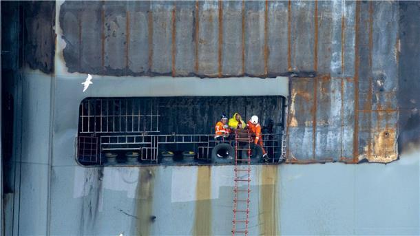 Nach Großfeuer: Beschädigter Frachter im sicheren Hafen Sicher im Hafen: Arbeiter an Bord des schwer beschädigten Autofrachters „Fremantle Highway“.
