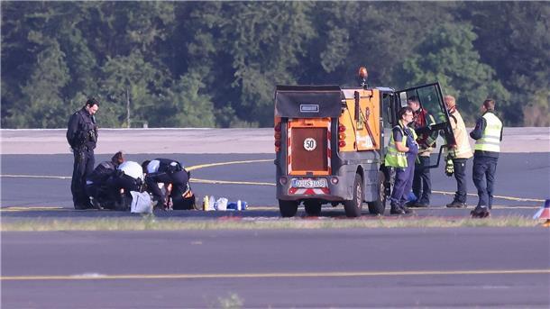 Klimaaktivisten stören bundesweit den Verkehr Sicherheitspersonal und Polizisten versuchen am Düsseldofer Flughafen, Aktivisten vom Asphalt auf dem Rollfeld zu lösen.