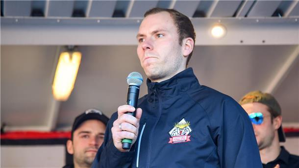 Eishockeyspieler Maximilian Franzreb mit einem Mikrofon in der Hand