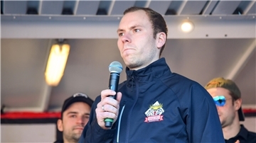 Eishockeyspieler Maximilian Franzreb mit einem Mikrofon in der Hand