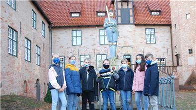 Sie alle waren am Schwert-Fund beteiligt (von links): Lilli Becker, Claas Bruns, Jonas Eybe, Connar von Thaden, Matthias Holtmann, Mesan Deks und Maximilian Koch vom Niedersächischen Internatsgymnasium vor der restaurierten Roland-Figur im Burghof von Bad Bederkesa.