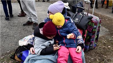 Sie bringen sich in Sicherheit: Eine Frau umarmt zwei Kinder auf der Flucht aus der Ukraine.