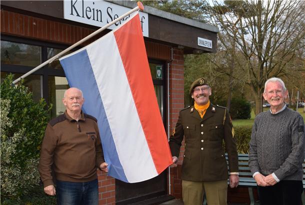 Sie erinnern sich als Zeitzeugen des Besuches von Prinz Bernhard im November 1972 in Seedorf und Zeven (von links): Albert de Geus, Jan Veldman in Original-Uniform und Ab de Graaf mit der niederländischen Flagge in "Klein Seedorf" vor der Kaserne.