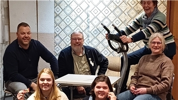 Zwei Männer und vier Frauen auf einer Theaterbühne. 