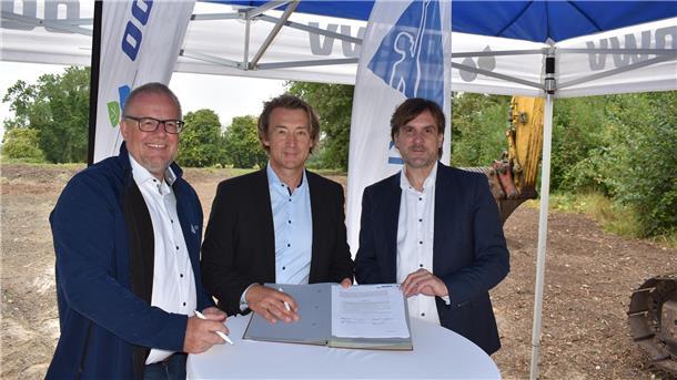 Vorreiter Kronos Titan produziert in Nordenham künftig mit recyceltem Wasser Drei Männer stehen an einem Tisch und zeigen eine Vereinbarung.