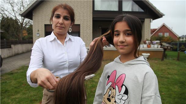 Siham Abdulfatah schneidet die Haarpracht ihrer Tochter Malak ab. Malak will die Haare spenden.