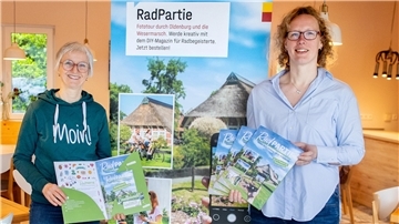 Zwei Frauen halten Prospekte