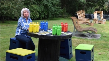 Eine Frau sitzt an einem Tisch mit Spielfiguren.
