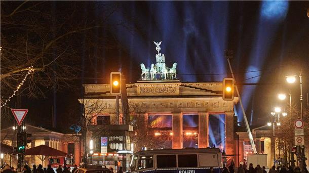 Silvester in Berlin: Polizeiwagen stehen vorm angestrahlten Brandenburger Tor.