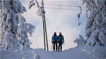 Skifahrer lassen sich am Sonnenberg im Oberharz mit einem Schlepplift den Berg hochziehen.