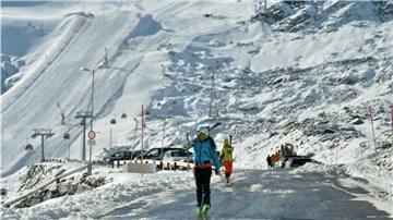Skiläufer gehen über den Parkplatz des Rettenbachgletschers in Sölden. Das Skigebiet gehört zu den beliebtesten in den österreichischen Alpen.