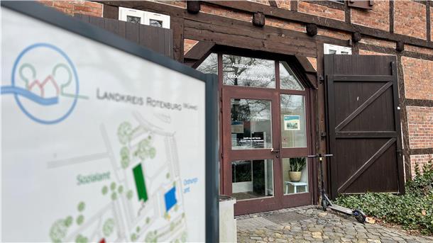 Eine gläserne Tür in einem Fachwerkhaus und davor ein Lageplan.