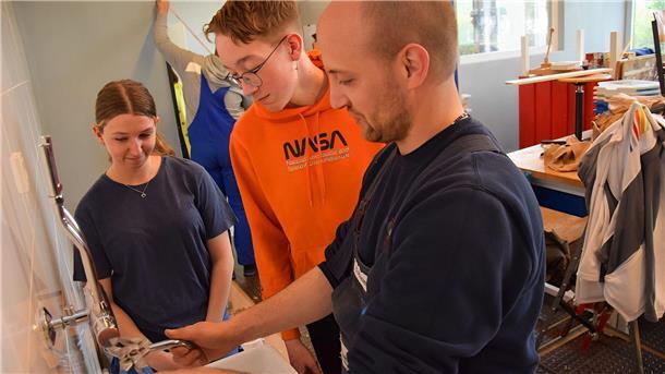 Projekttage an der Oberschule 1 in Nordenham: Neuntklässler sanieren Räume mit So montiert man einen Wasserhahn: Daniel Porschen von der Firma Quaritsch zeigt es den Schülern Milena Lesner und Maximilian Bittner.