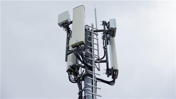 Hier steht in Nordenham jetzt ein neuer Mobilfunkmast Im Vordergrund ist ein Mobilfunkmast zu sehen, dahinter ein wolkenverhangener grauer Himmel.