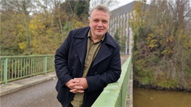 Ein Mann lehnt auf dem Geländer eine Brücke