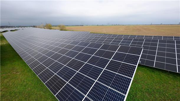 Solaranlagen sind für ein Photovoltaik-Speicher-Kraftwerk auf einer Wiese montiert.