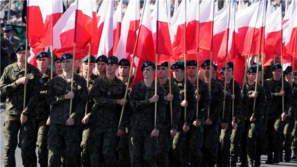 Frontstaat Polen demonstriert mit Militärparade Stärke Soldaten tragen polnische Nationalfahnen während einer Militärparade am Tag der polnischen Streitkräfte.