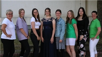 Vladlena trägt ihr neues Abendkleid, umringt von Freundinnen und Klassenlehrerin