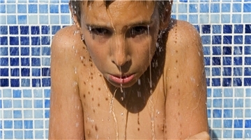Ein Kinder unter der Dusche friert.