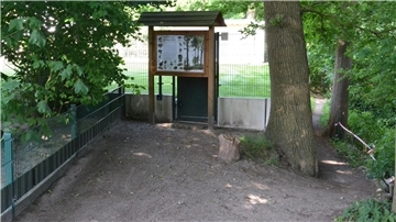 Spaziergänger aus Richtung Offensen biegen vor dem Grundstückszaun und der Schautafel rechts ab auf den Trampelpfad, um den Weg fortsetzen zu können. Privatgrund betreten sie nicht.