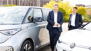 SPD-Bundesvorsitzender Lars Klingbeil (links) steht neben elektroangetriebenen Volkswagen-Modellen auf dem Gelände vom Volkswagen-Stammwerk.